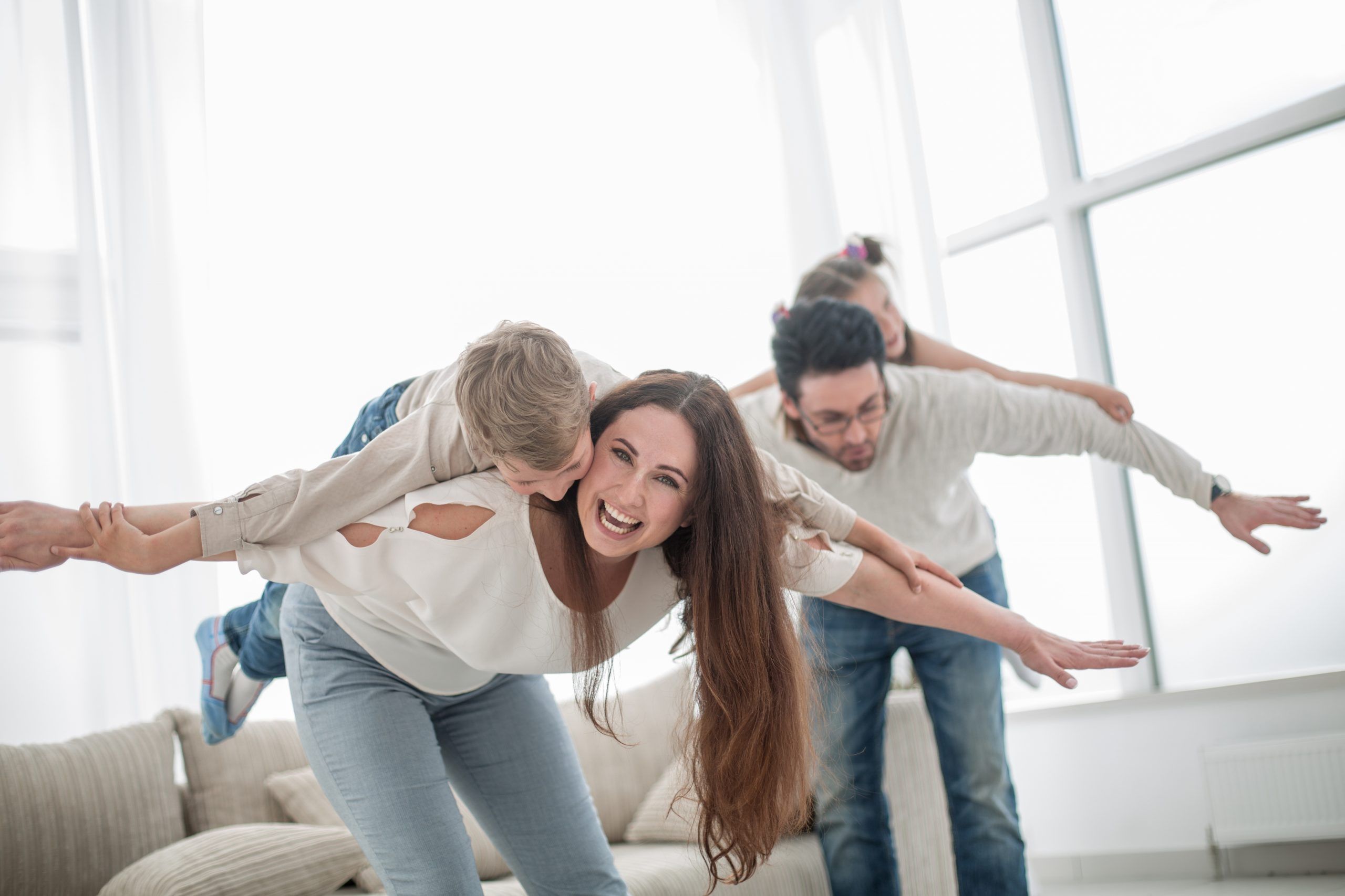 Eine laechelnde Familie hat Spaß im Wohnzimmer, symbolisiert Freude und Energie.